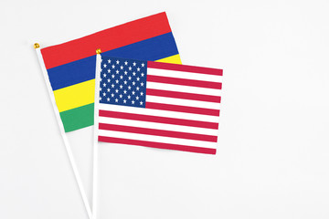 United States and Mauritius stick flags on white background. High quality fabric, miniature national flag. Peaceful global concept.White floor for copy space.