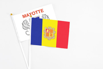 Andorra and Mayotte stick flags on white background. High quality fabric, miniature national flag. Peaceful global concept.White floor for copy space.