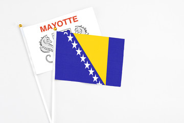 Bosnia Herzegovina and Mayotte stick flags on white background. High quality fabric, miniature national flag. Peaceful global concept.White floor for copy space.