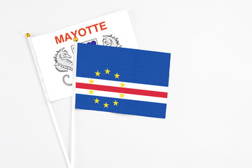 Cape Verde and Mayotte stick flags on white background. High quality fabric, miniature national flag. Peaceful global concept.White floor for copy space.