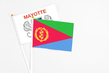 Eritrea and Mayotte stick flags on white background. High quality fabric, miniature national flag. Peaceful global concept.White floor for copy space.