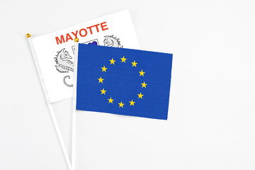 European Union and Mayotte stick flags on white background. High quality fabric, miniature national flag. Peaceful global concept.White floor for copy space.