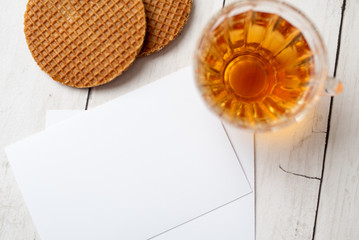 Cup of tea with German caramel waffles on white wooden table