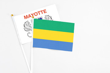 Gabon and Mayotte stick flags on white background. High quality fabric, miniature national flag....