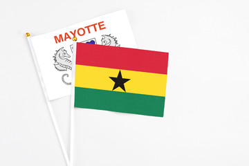 Ghana and Mayotte stick flags on white background. High quality fabric, miniature national flag. Peaceful global concept.White floor for copy space.