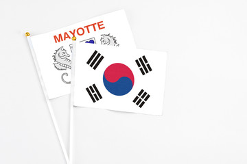 South Korea and Mayotte stick flags on white background. High quality fabric, miniature national flag. Peaceful global concept.White floor for copy space.