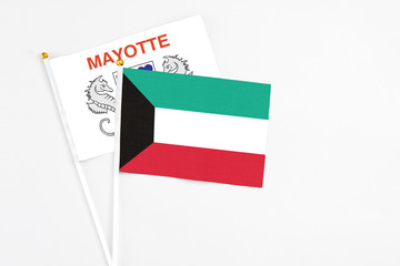 Kuwait and Mayotte stick flags on white background. High quality fabric, miniature national flag. Peaceful global concept.White floor for copy space.