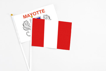 Peru and Mayotte stick flags on white background. High quality fabric, miniature national flag. Peaceful global concept.White floor for copy space.