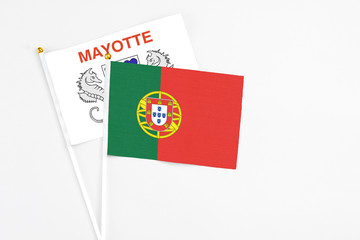 Naklejka na ściany i meble Portugal and Mayotte stick flags on white background. High quality fabric, miniature national flag. Peaceful global concept.White floor for copy space.
