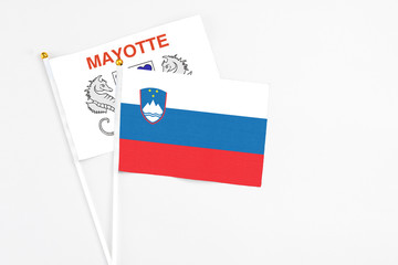 Slovenia and Mayotte stick flags on white background. High quality fabric, miniature national flag. Peaceful global concept.White floor for copy space.