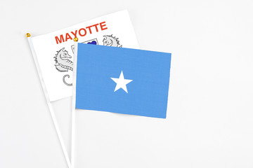Somalia and Mayotte stick flags on white background. High quality fabric, miniature national flag. Peaceful global concept.White floor for copy space.