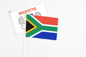 South Africa and Mayotte stick flags on white background. High quality fabric, miniature national flag. Peaceful global concept.White floor for copy space.