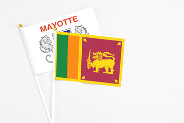 Sri Lanka and Mayotte stick flags on white background. High quality fabric, miniature national flag. Peaceful global concept.White floor for copy space.