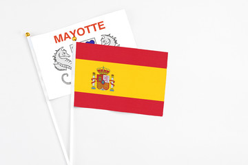 Spain and Mayotte stick flags on white background. High quality fabric, miniature national flag. Peaceful global concept.White floor for copy space.