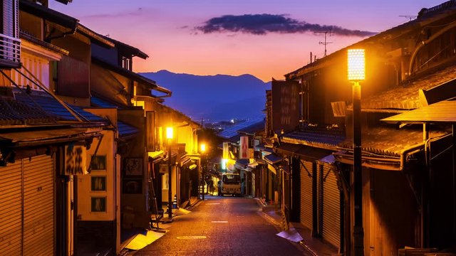 Kyoto, Japan. A night view of narrow street with a row of old japanese shops and houses in Kyoto, Japan. Time-lapse furing the sunset