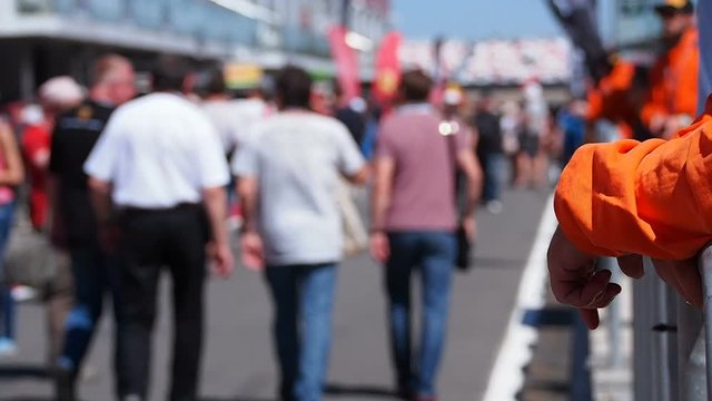 Blurred Out Crowd Walking on a Raceway Pitlane