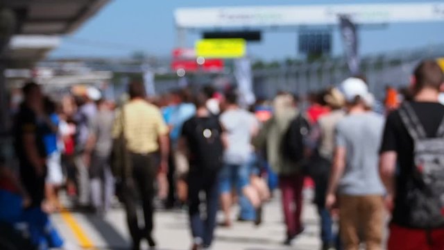 Blurred Out Crowd Walking on a Raceway Pitlane