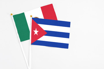Obraz premium Cuba and Mexico stick flags on white background. High quality fabric, miniature national flag. Peaceful global concept.White floor for copy space.