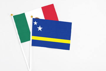 Curacao and Mexico stick flags on white background. High quality fabric, miniature national flag. Peaceful global concept.White floor for copy space.