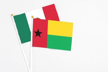 Guinea Bissau and Mexico stick flags on white background. High quality fabric, miniature national flag. Peaceful global concept.White floor for copy space.