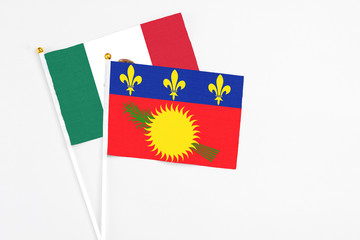 Guadeloupe and Mexico stick flags on white background. High quality fabric, miniature national flag. Peaceful global concept.White floor for copy space.