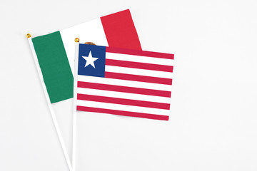 Liberia and Mexico stick flags on white background. High quality fabric, miniature national flag. Peaceful global concept.White floor for copy space.