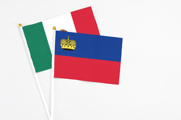 Liechtenstein and Mexico stick flags on white background. High quality fabric, miniature national flag. Peaceful global concept.White floor for copy space.