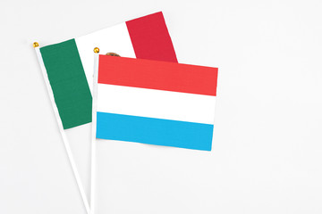 Luxembourg and Mexico stick flags on white background. High quality fabric, miniature national flag. Peaceful global concept.White floor for copy space.