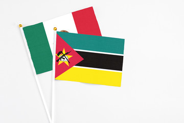 Mozambique and Mexico stick flags on white background. High quality fabric, miniature national flag. Peaceful global concept.White floor for copy space.