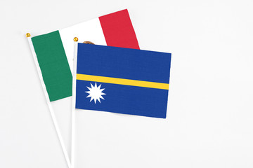 Nauru and Mexico stick flags on white background. High quality fabric, miniature national flag. Peaceful global concept.White floor for copy space.