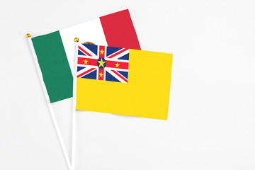 Niue and Mexico stick flags on white background. High quality fabric, miniature national flag. Peaceful global concept.White floor for copy space.