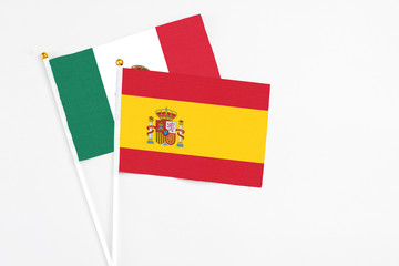 Spain and Mexico stick flags on white background. High quality fabric, miniature national flag. Peaceful global concept.White floor for copy space.