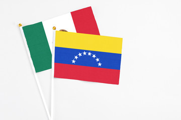 Venezuela and Mexico stick flags on white background. High quality fabric, miniature national flag. Peaceful global concept.White floor for copy space.