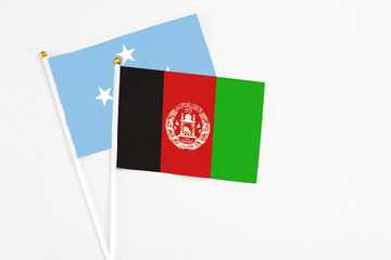 Afghanistan and Micronesia stick flags on white background. High quality fabric, miniature national flag. Peaceful global concept.White floor for copy space.