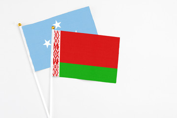 Belarus and Micronesia stick flags on white background. High quality fabric, miniature national flag. Peaceful global concept.White floor for copy space.