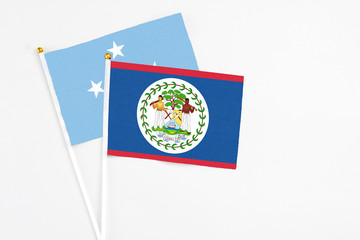 Belize and Micronesia stick flags on white background. High quality fabric, miniature national flag. Peaceful global concept.White floor for copy space.