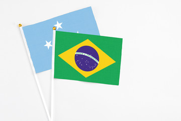 Brazil and Micronesia stick flags on white background. High quality fabric, miniature national flag. Peaceful global concept.White floor for copy space.