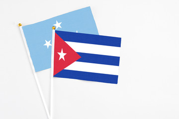 Cuba and Micronesia stick flags on white background. High quality fabric, miniature national flag. Peaceful global concept.White floor for copy space.