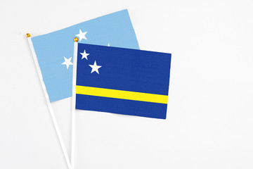 Curacao and Micronesia stick flags on white background. High quality fabric, miniature national flag. Peaceful global concept.White floor for copy space.
