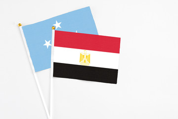 Egypt and Micronesia stick flags on white background. High quality fabric, miniature national flag. Peaceful global concept.White floor for copy space.