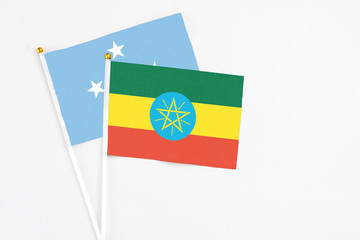 Ethiopia and Micronesia stick flags on white background. High quality fabric, miniature national flag. Peaceful global concept.White floor for copy space.