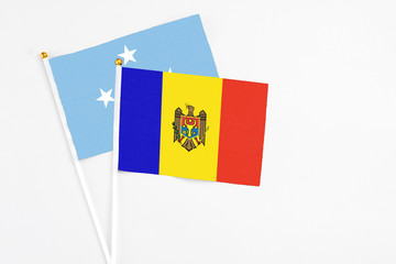 Moldova and Micronesia stick flags on white background. High quality fabric, miniature national flag. Peaceful global concept.White floor for copy space.