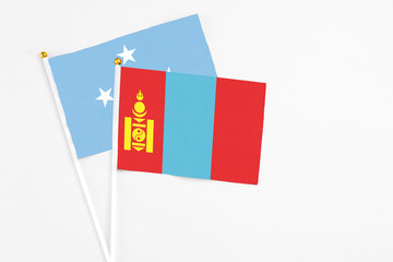 Mongolia and Micronesia stick flags on white background. High quality fabric, miniature national flag. Peaceful global concept.White floor for copy space.