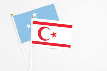 Northern Cyprus and Micronesia stick flags on white background. High quality fabric, miniature national flag. Peaceful global concept.White floor for copy space.