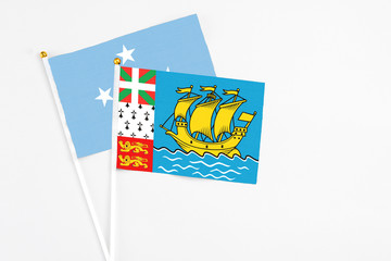 Saint Pierre And Miquelon and Micronesia stick flags on white background. High quality fabric, miniature national flag. Peaceful global concept.White floor for copy space.