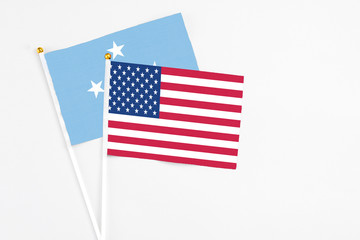 United States and Micronesia stick flags on white background. High quality fabric, miniature national flag. Peaceful global concept.White floor for copy space.