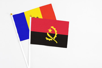 Angola and Moldova stick flags on white background. High quality fabric, miniature national flag. Peaceful global concept.White floor for copy space.