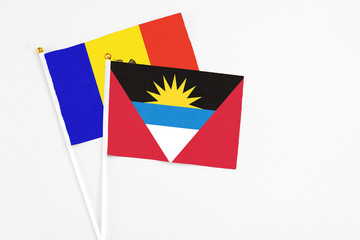 Antigua and Barbuda and Moldova stick flags on white background. High quality fabric, miniature national flag. Peaceful global concept.White floor for copy space.