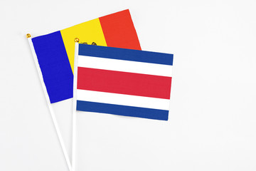Costa Rica and Moldova stick flags on white background. High quality fabric, miniature national flag. Peaceful global concept.White floor for copy space.