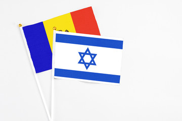 Israel and Moldova stick flags on white background. High quality fabric, miniature national flag. Peaceful global concept.White floor for copy space.